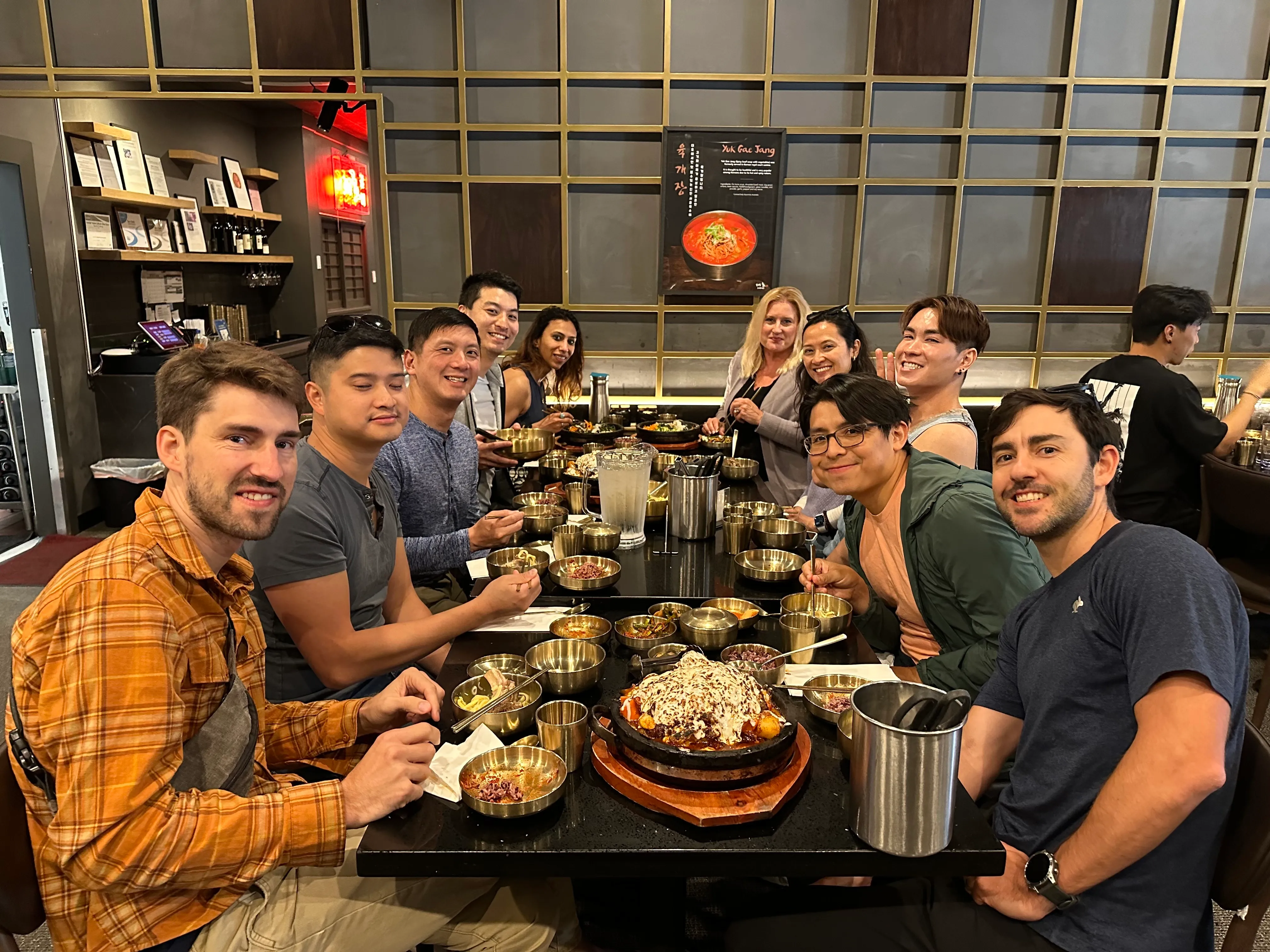 a group of jampack employees sitting around a table with food